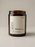 Candle jar labeled 'Cabin' on a beige background