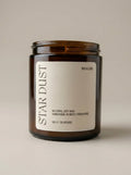 Candle with 'Star Dust' label on a beige background